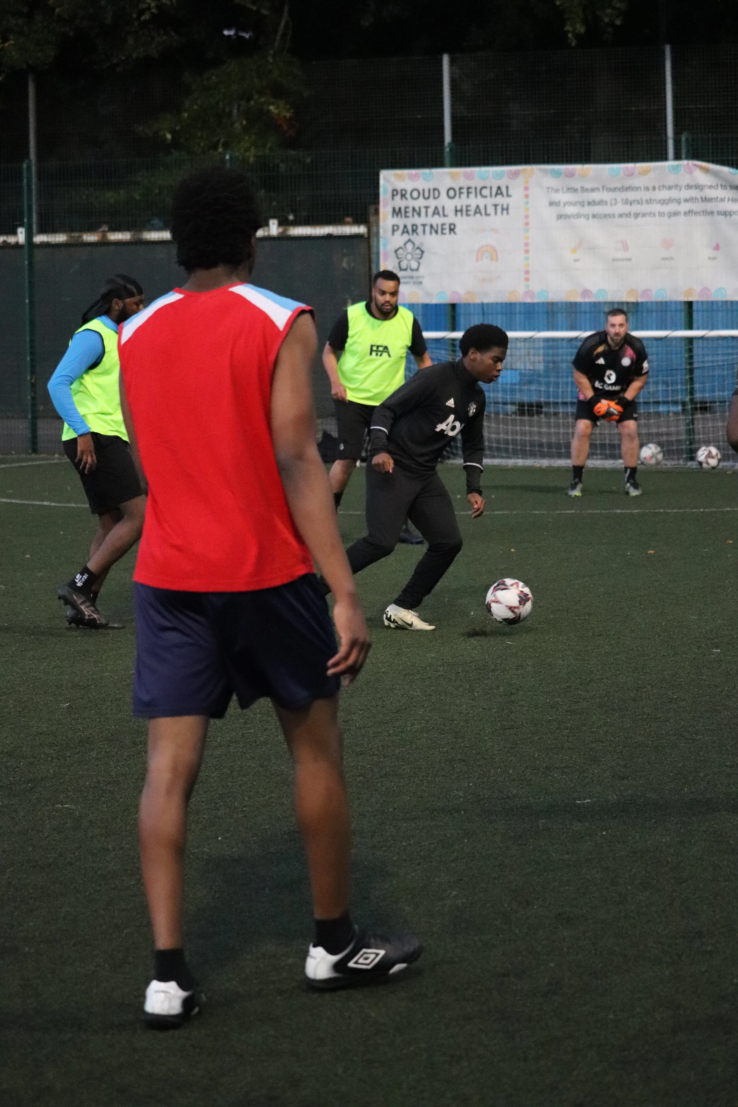 Group of men playing soccer on an outdoor field during daytime.