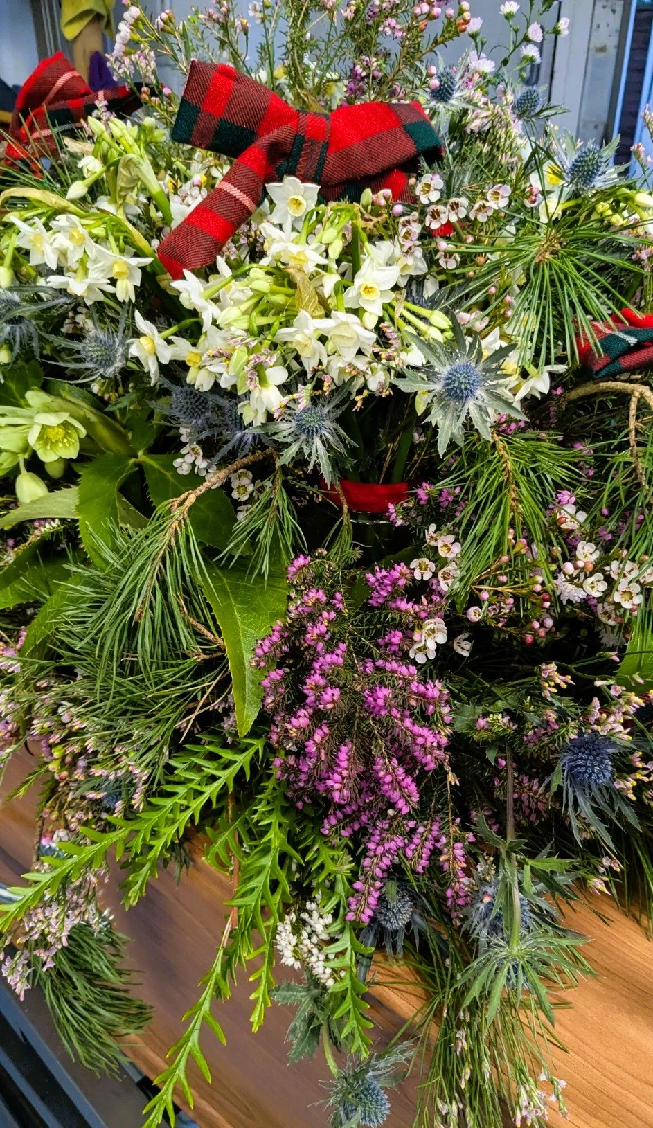 A tribute of flowers made for a Scotsman. I added bows of tartan made out of his kilt.