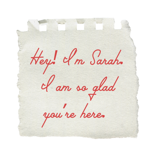 A torn piece of paper with a message that reads, 'Hey! I m Sarah. I am so glad you're here.' in red cursive handwriting.