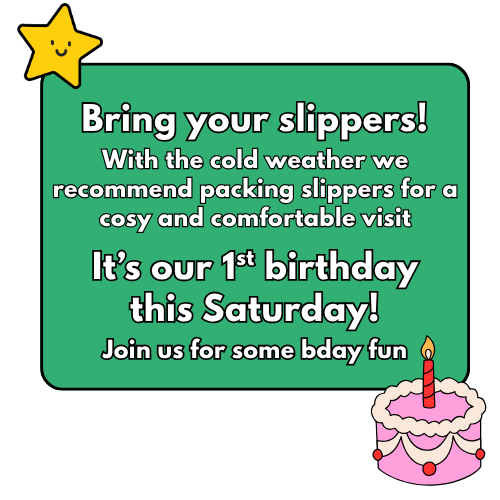 Green birthday invitation card with a yellow star character in the top left corner and a pink birthday cake with a lit candle in the bottom right corner. The text invites bringing slippers and mentions a first birthday celebration on Saturday.