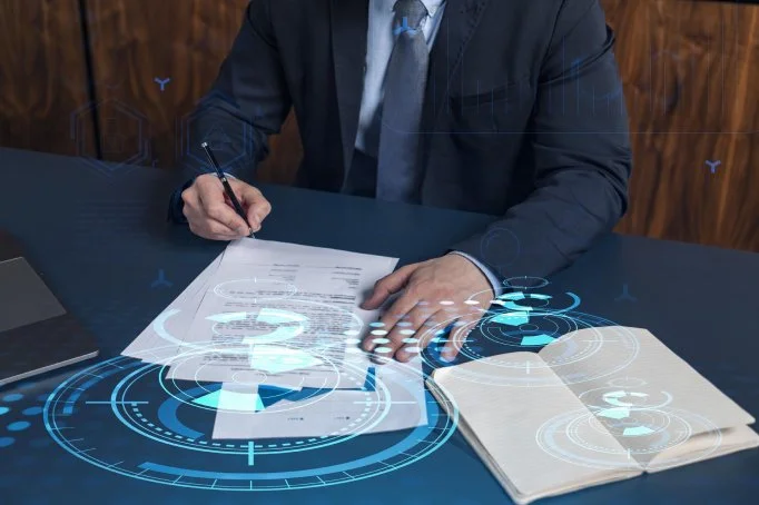 Business person in suit at desk with digital holographic interface and documents.