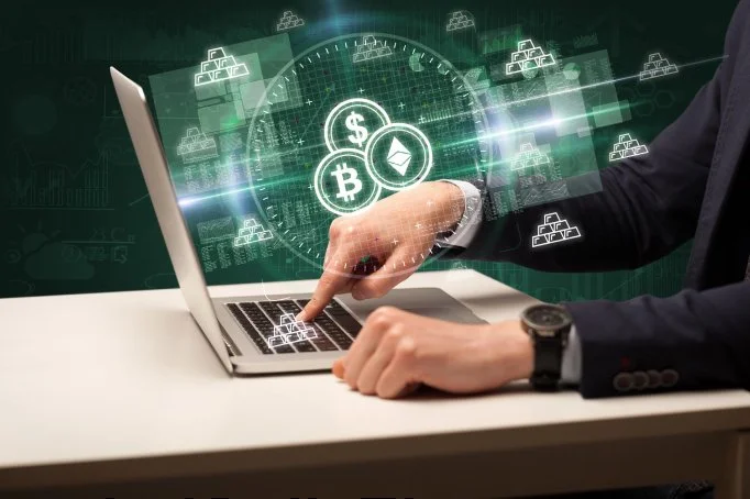 Person in business suit using a laptop, with digital icons of cryptocurrencies like Bitcoin, Bitcoin Cash, Ethereum, and Dollar signs floating above the keyboard, indicating digital currency trading or blockchain technology.