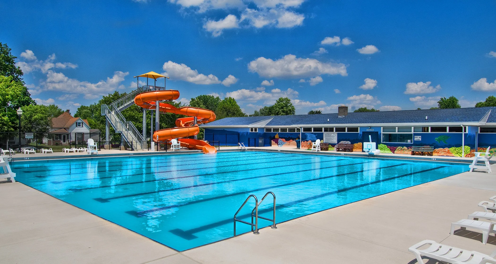 Image contains a pool with an orange waterslide.