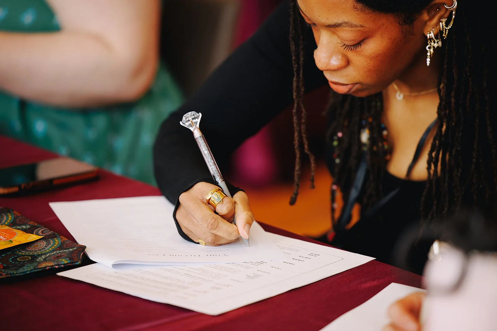 A woman taking notes at Collective Vow conference in Columbus, Ohio feeling inspired and concentrating hard.