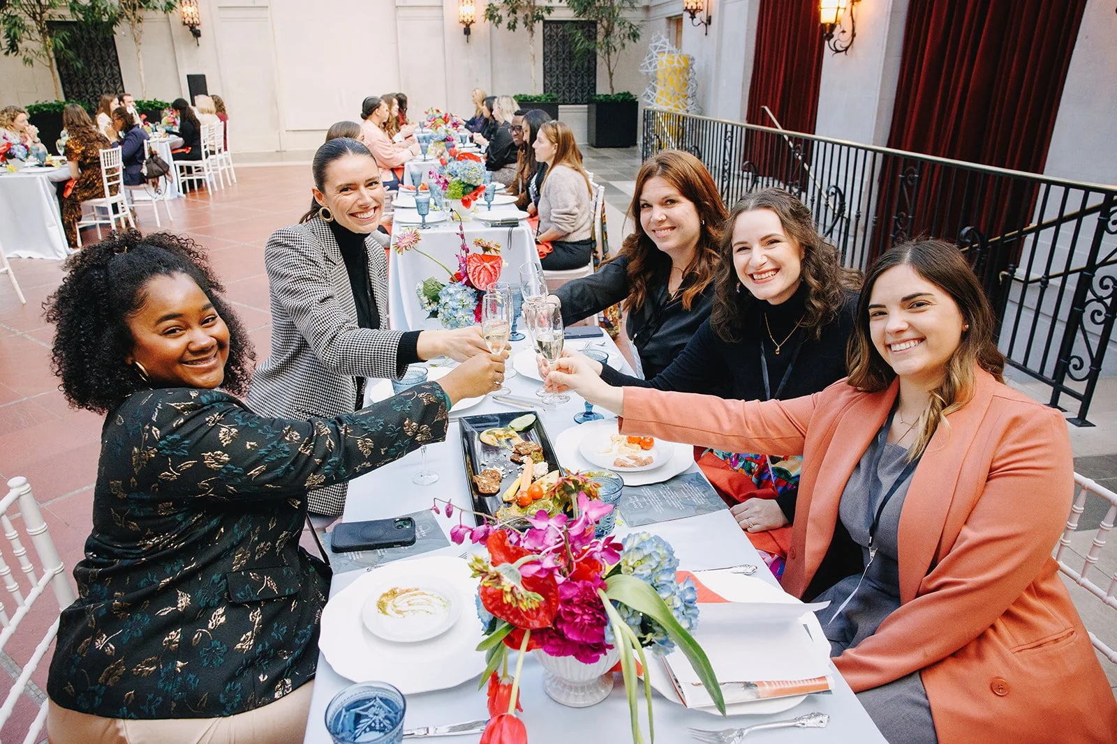 Collective Vow attendees raising champagne glasses during the conference luncheon.