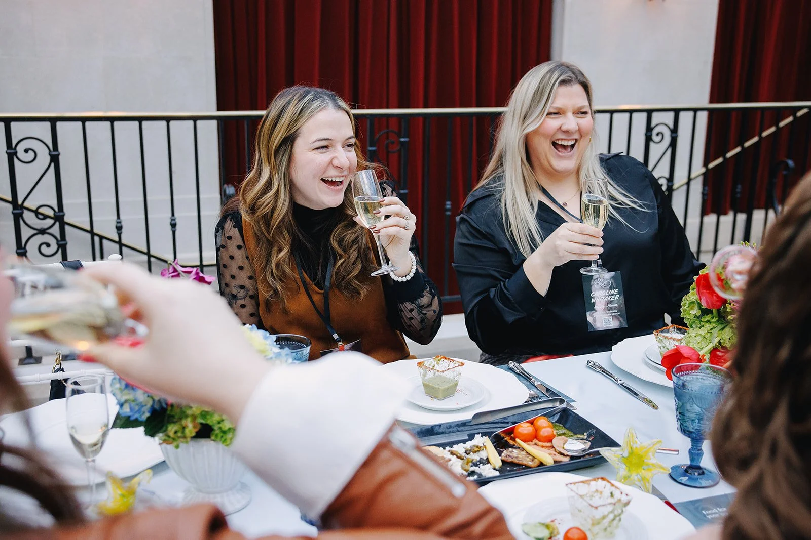 Wedding professionals laughing over champagne at the Collective Vow conference in Columbus, Ohio.