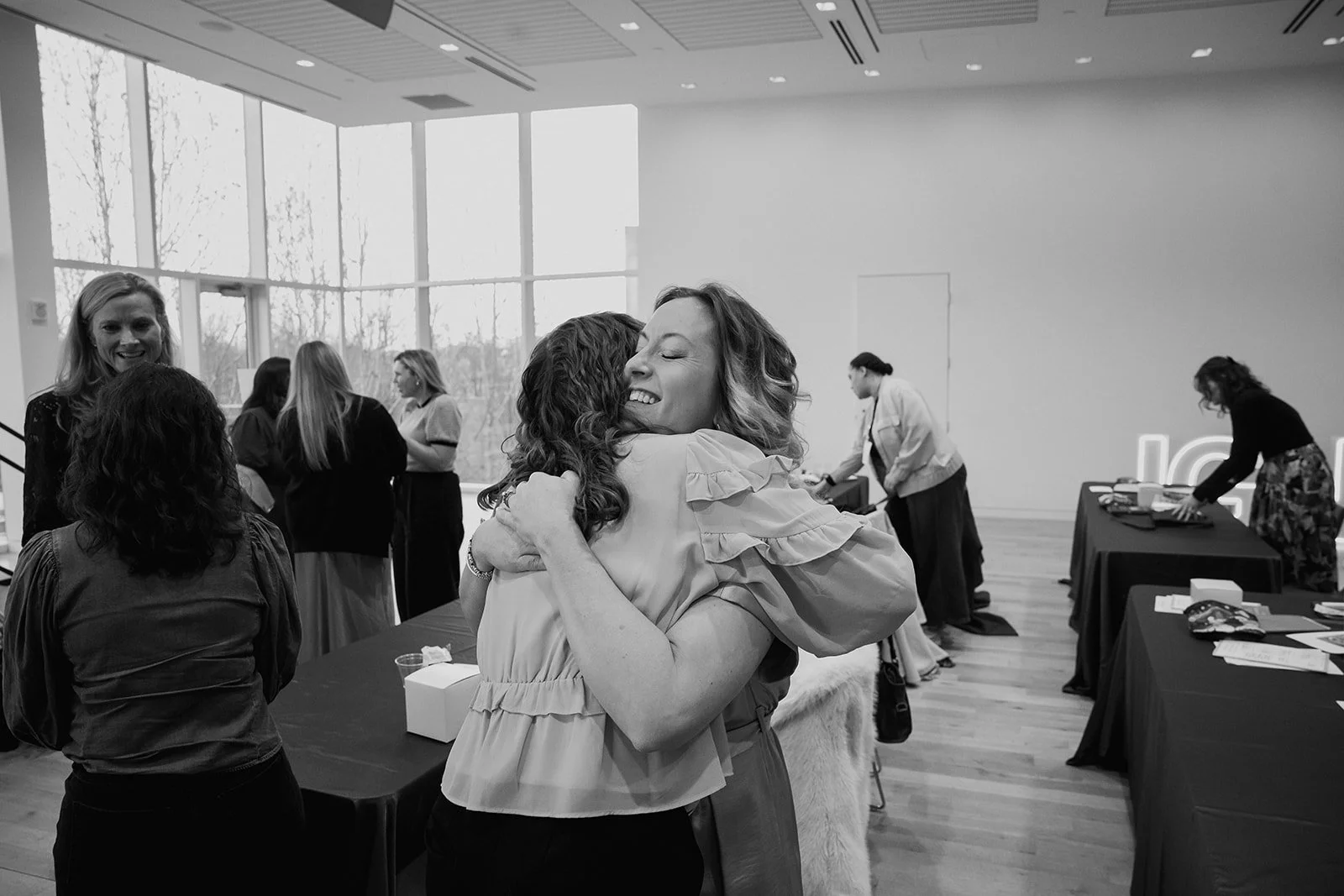 Two women embrace happily at Collective Vow conference for wedding creatives in Columbus, Ohio.