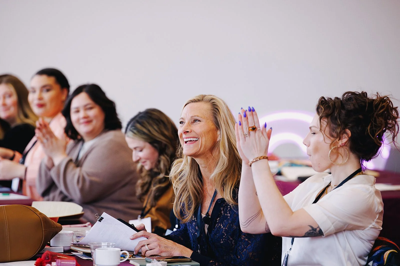 Wedding professionals smiling and applauding during a Collective Vow educational session.