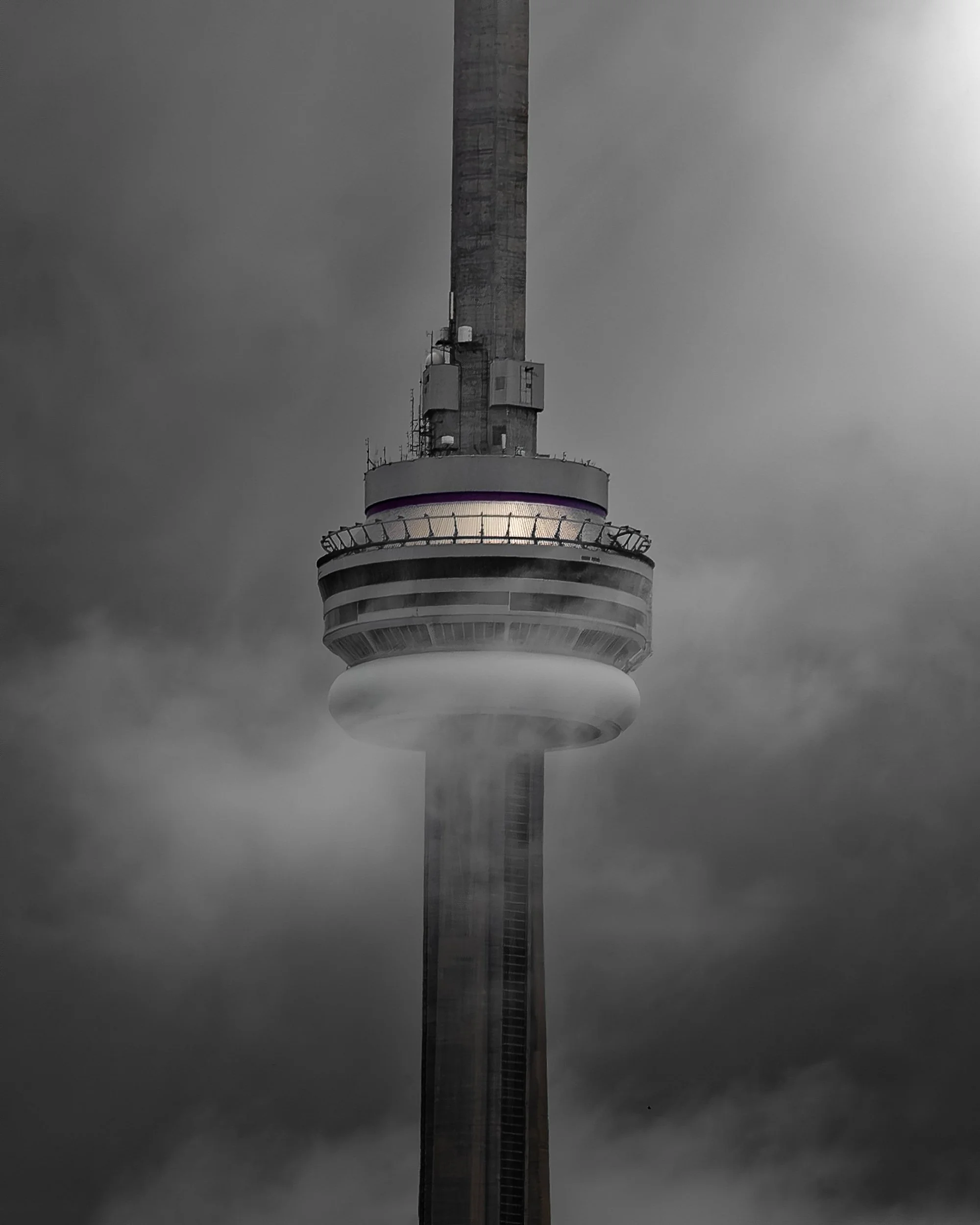 A tall communications tower with an observation deck and an overcast sky in the background.