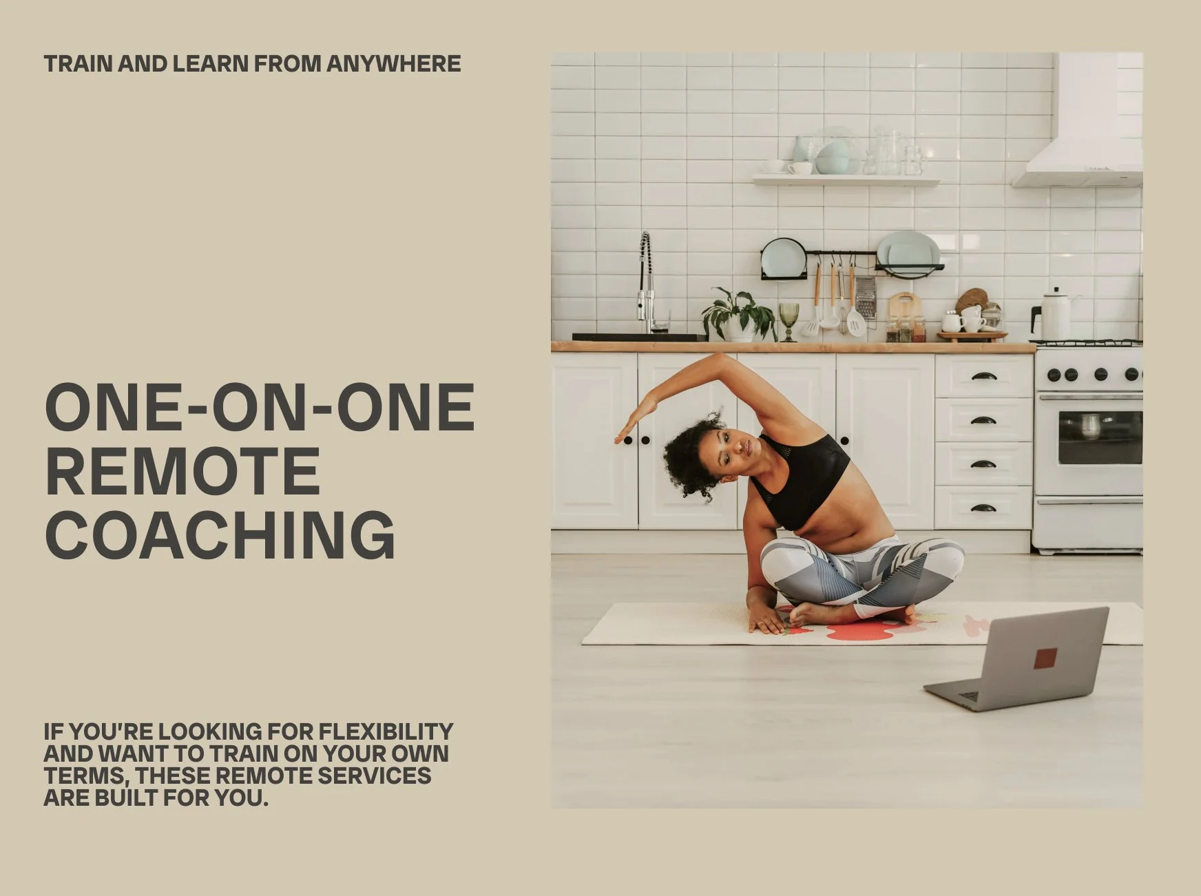 A woman practicing yoga in a kitchen, sitting in a cross-legged pose and stretching her arm over her head, with a laptop open on the floor nearby.
