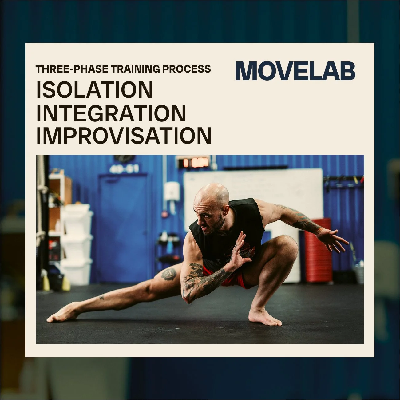 A man with tattoos performing a stretch or martial arts move on the floor in a gym setting with blue walls and exercise equipment in the background.