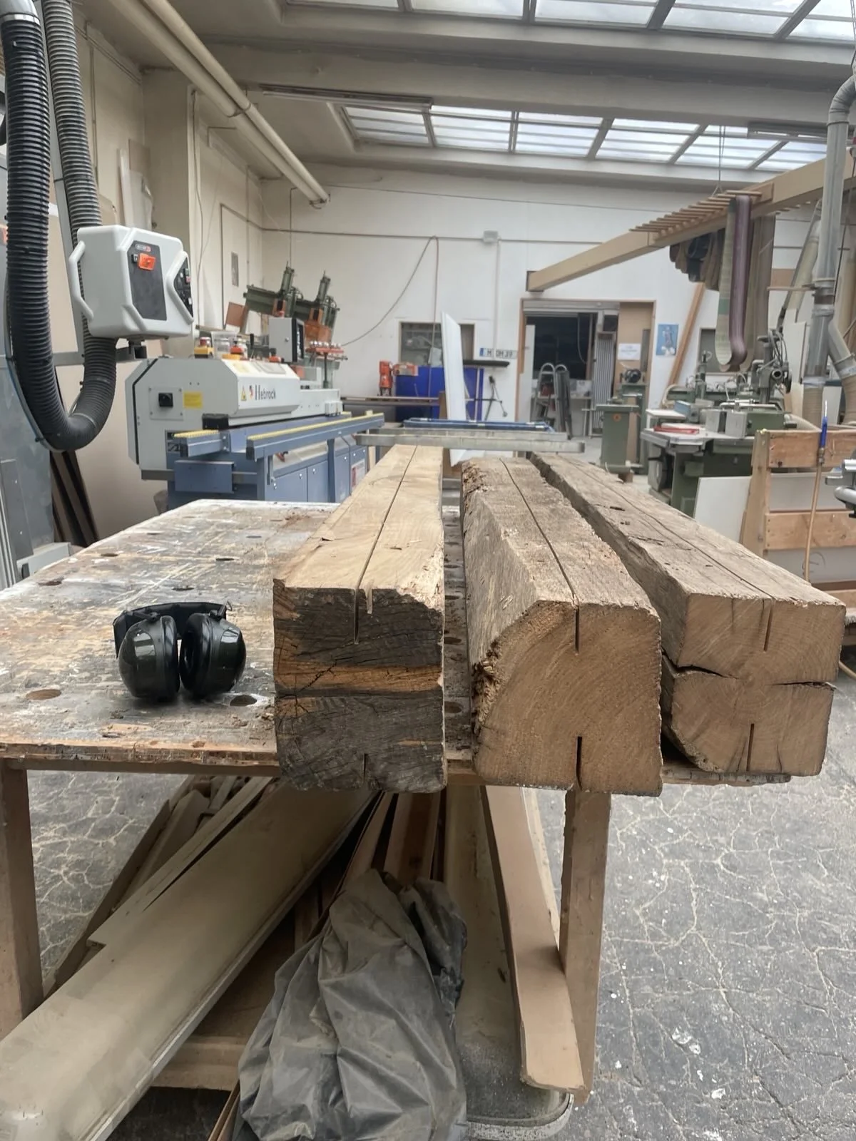 Alte Holzbalken werden zugesägt.