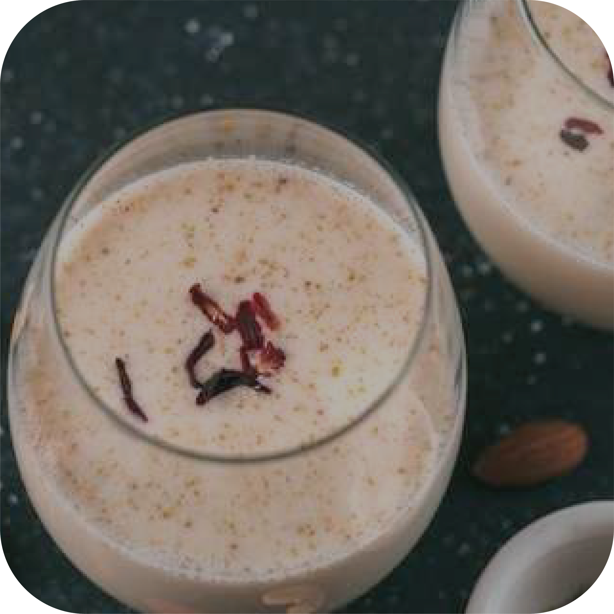 Glass of poppy seed milk with nuts on a dark surface