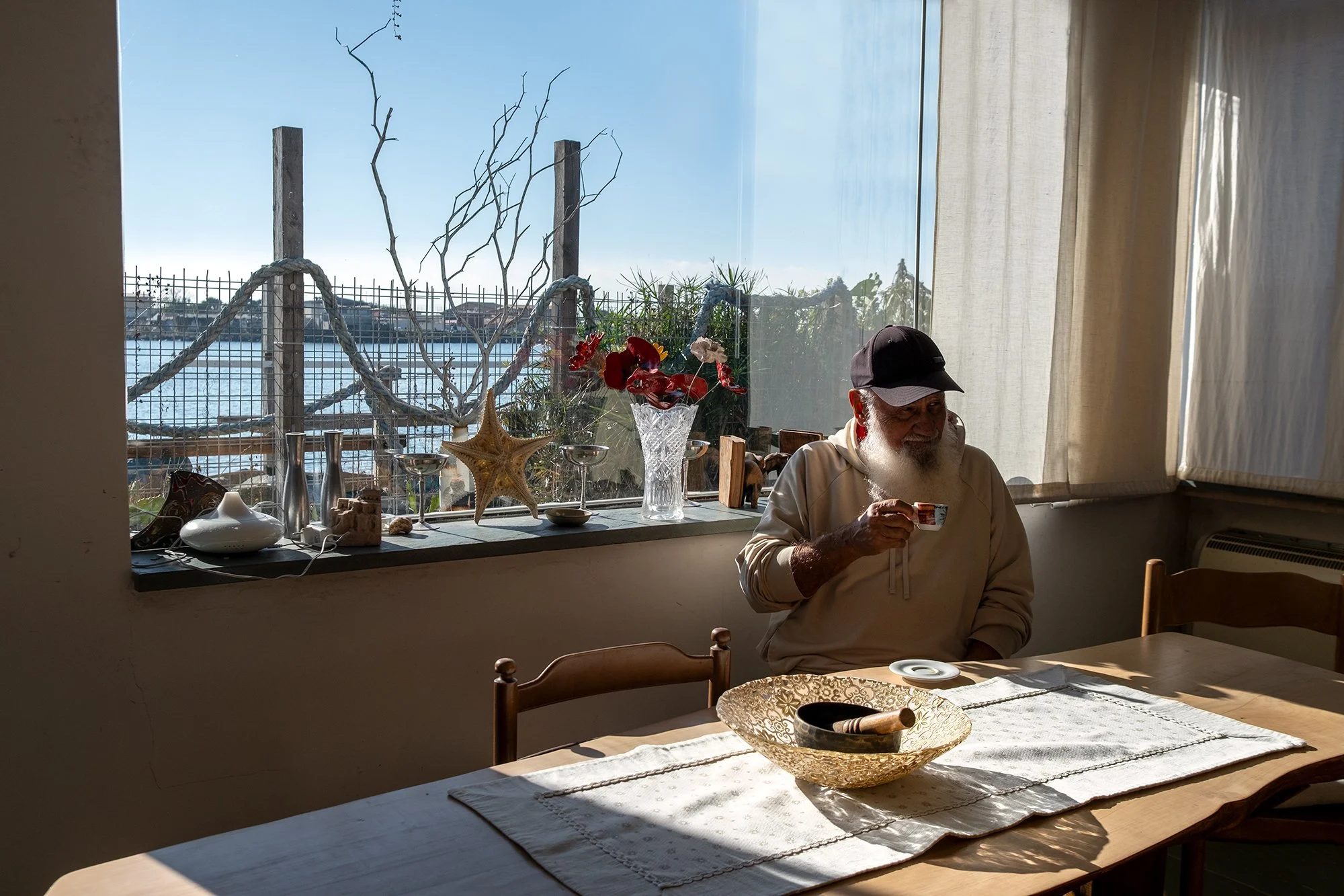 Inhabitant of Passo della Sentinella inside his home, Tiber River backdrop, 2025