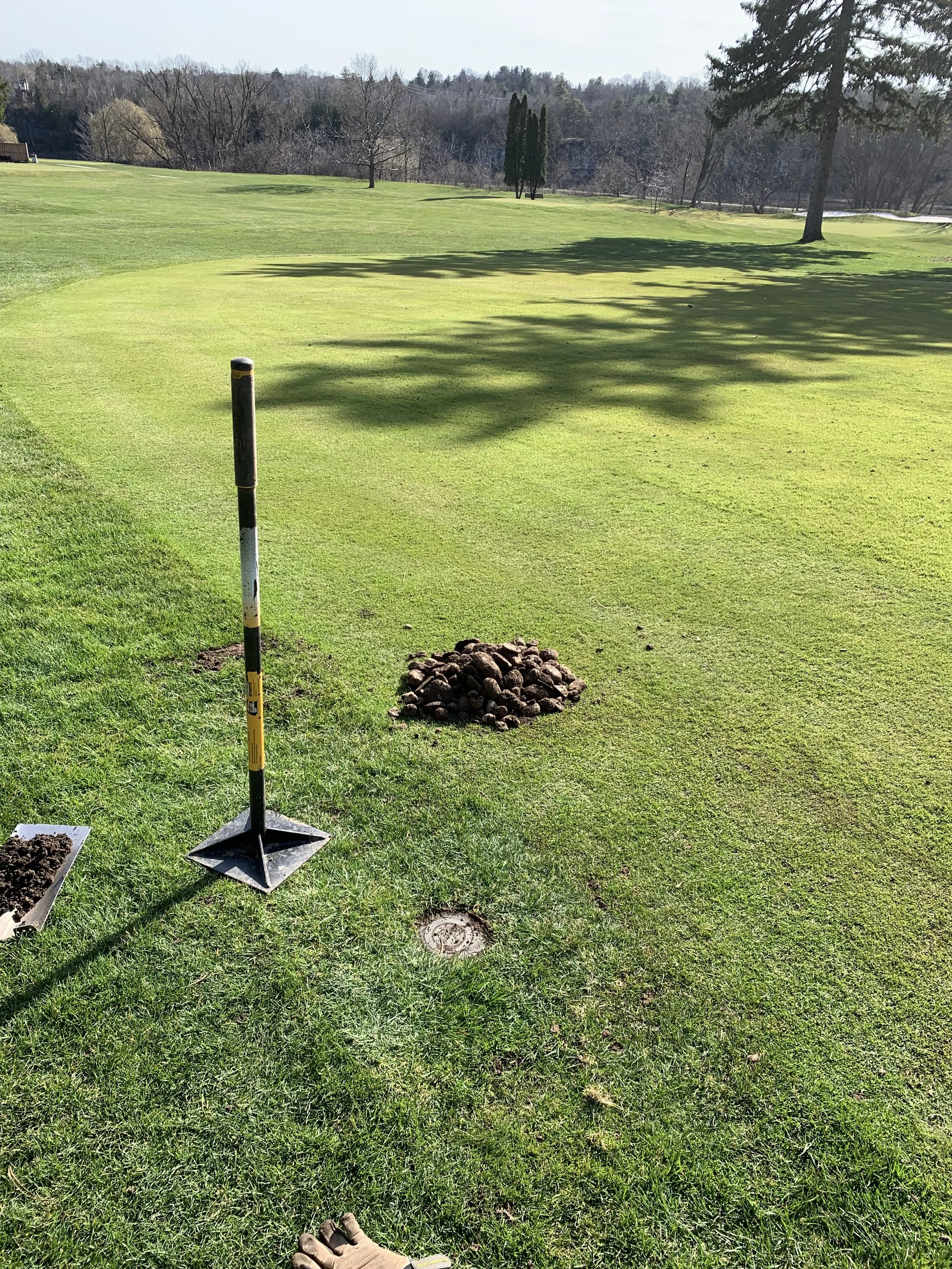 An irrigation head raised and levelled next to a pile of rocks that were removed from the hole.