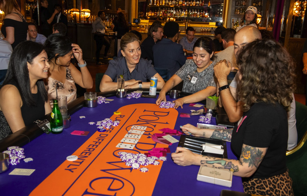 People playing poker at a table in a lively bar or casino setting.