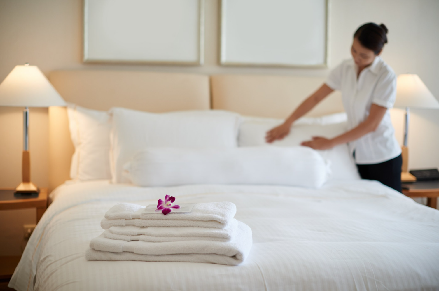 Eine Frau macht gerade ein Bett zurecht