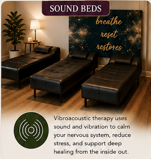 Three black leather sound therapy beds in a room with a lamp, a potted plant, and a large poster with the words 'breathe, reset, restores' and a description of vibroacoustic therapy.