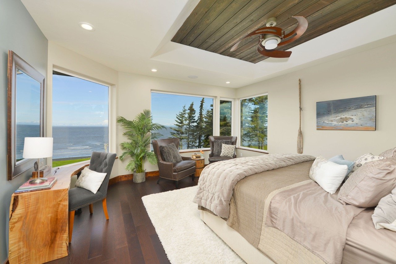 Coastal bedroom with ocean and spruce tree views, leather chairs, live-edge desk - coastal interior design, Designer Interiors
