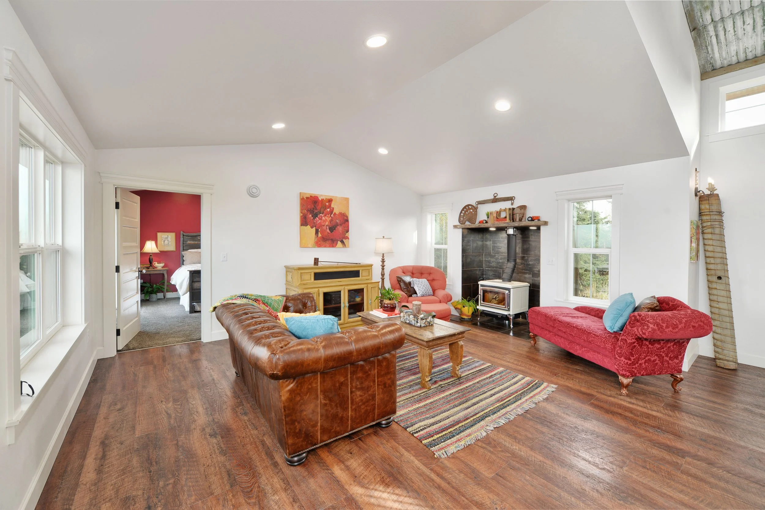 Leather Chesterfield sofa, striped rug, wood stove and hardwood floors - modern rustic interior design, Designer Interiors