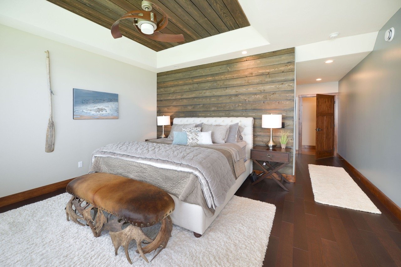 Reclaimed wood accent wall, white tufted bed, antler bench, vintage oar - Alaska interior design, Designer Interiors