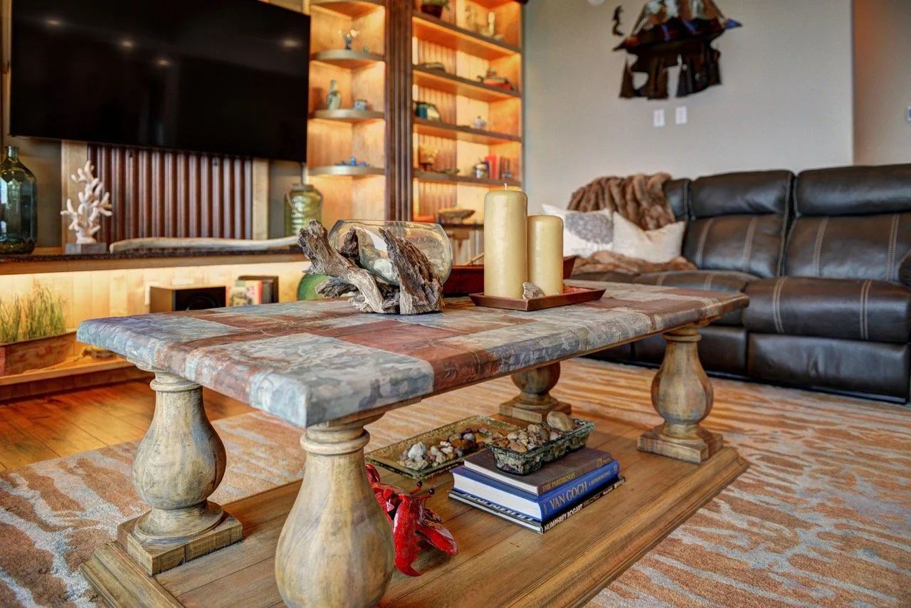 Stone-top coffee table with driftwood, candle, leather sofa and patterned rug - mountain modern interior design, Designer Interiors