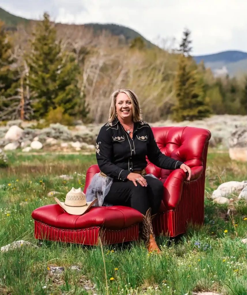 Chanda Wahl in red leather chair, Montana meadow, western shirt - interior designers Montana, Designer Interiors