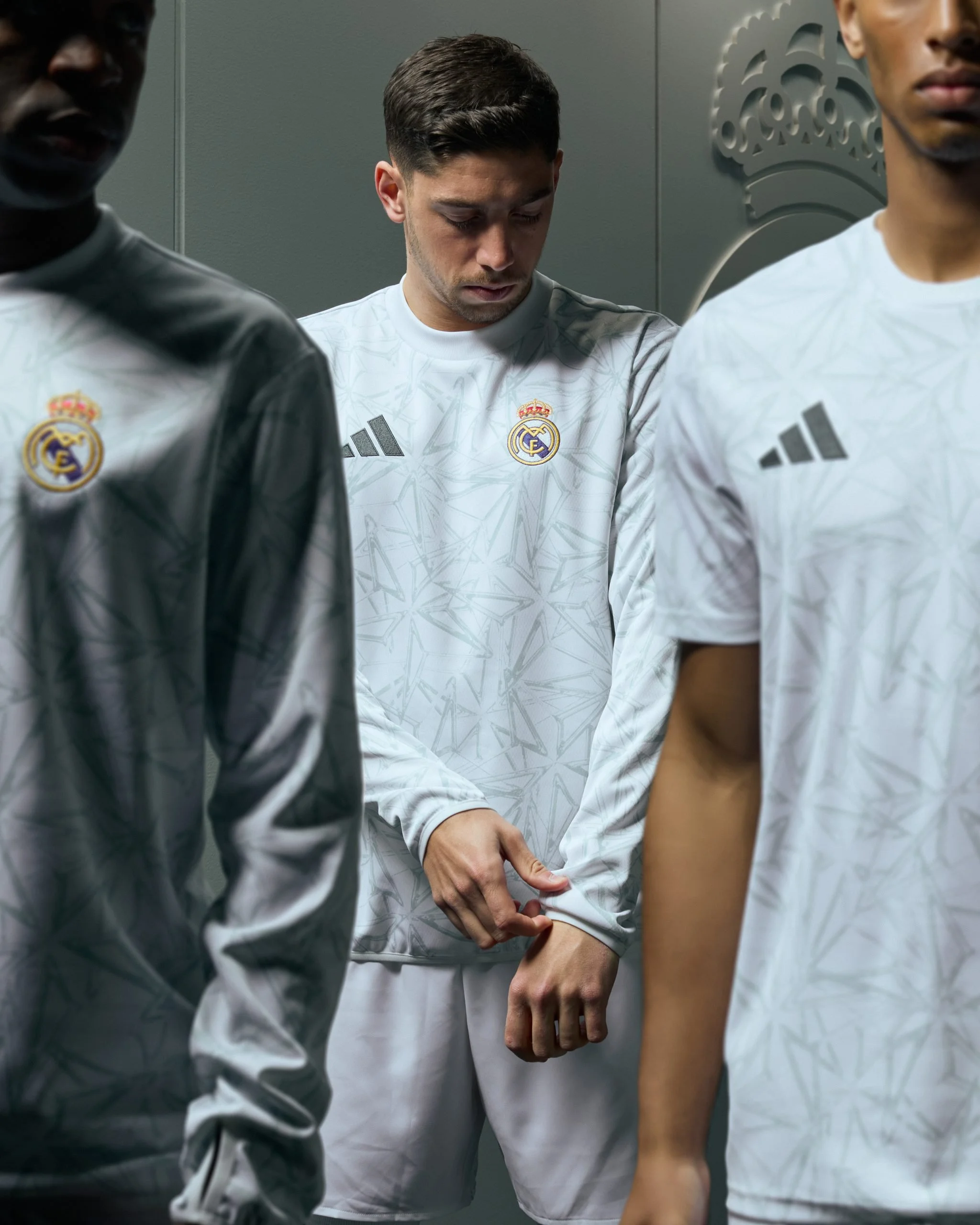Jugadores del Real Madrid en el vestuario, uno ajustándose la manga de la camiseta.