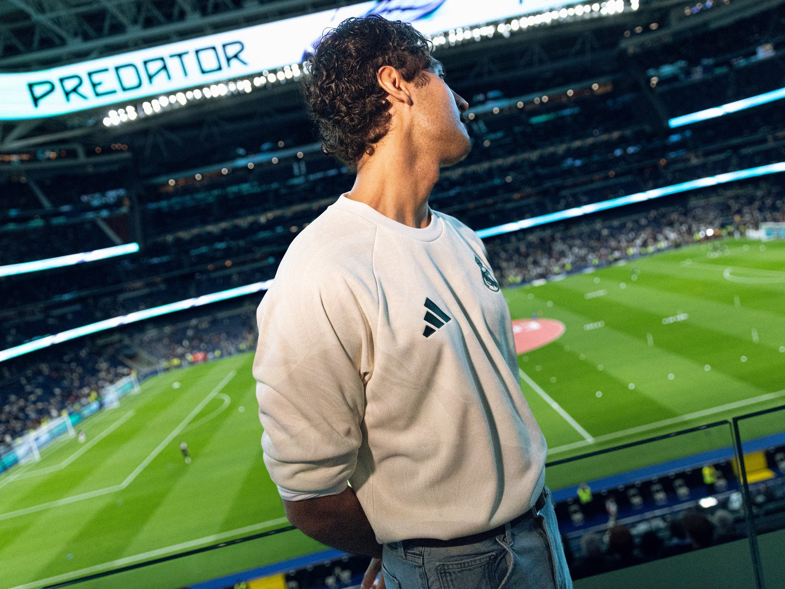 Invitado con camiseta de Real Madrid junto al campo durante el evento FARM Rio en Madrid