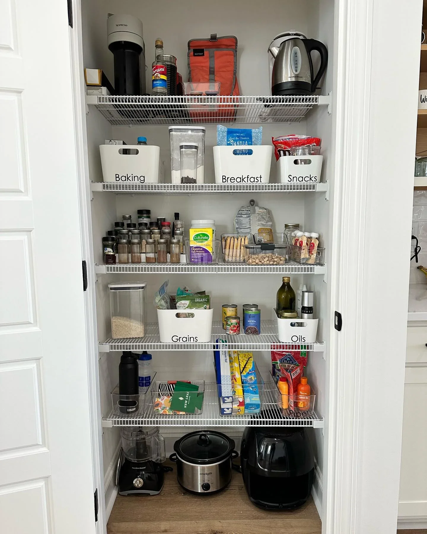 Professional pantry organization by Organize to Live NC in Raleigh, featuring labeled white bins and clear containers on wire shelving.