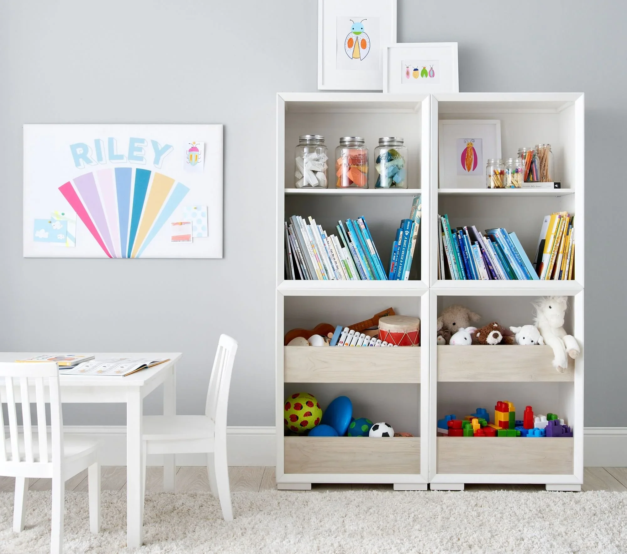 Organized children's playroom by We Organize in Seattle, featuring a white bookshelf with neatly arranged books, toy bins, and art supplies.