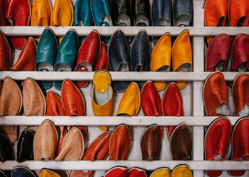 Rows of colorful leather shoes neatly organized on white shelving by Amélie Organizes.