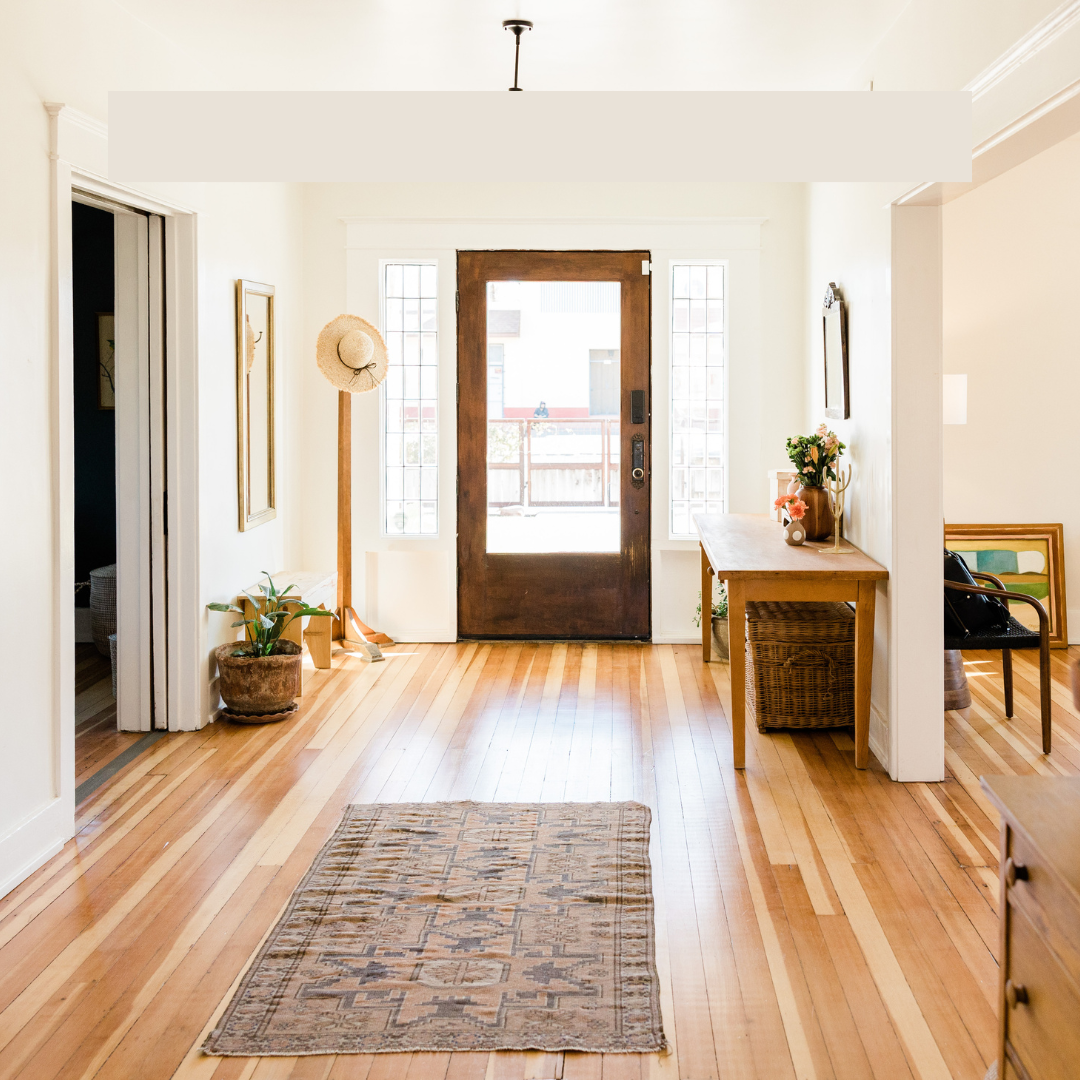 Bright, organized home entryway with wood floors, minimalist decor, and a woven basket.