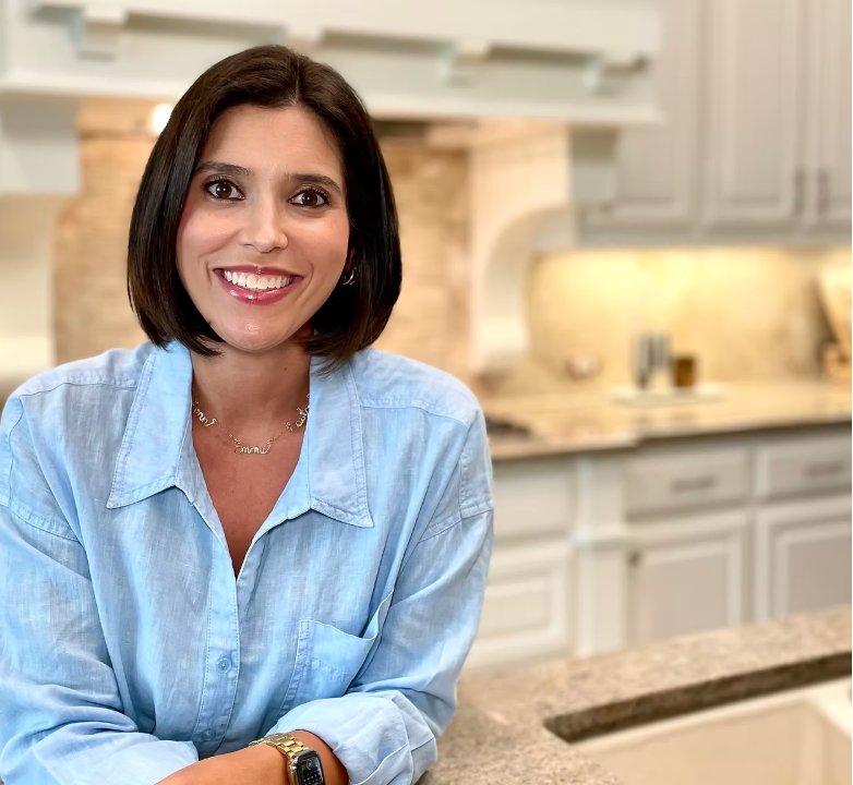 Amanda, founder of Fall In Place professional home organizing in Dallas, smiling in a bright modern kitchen.