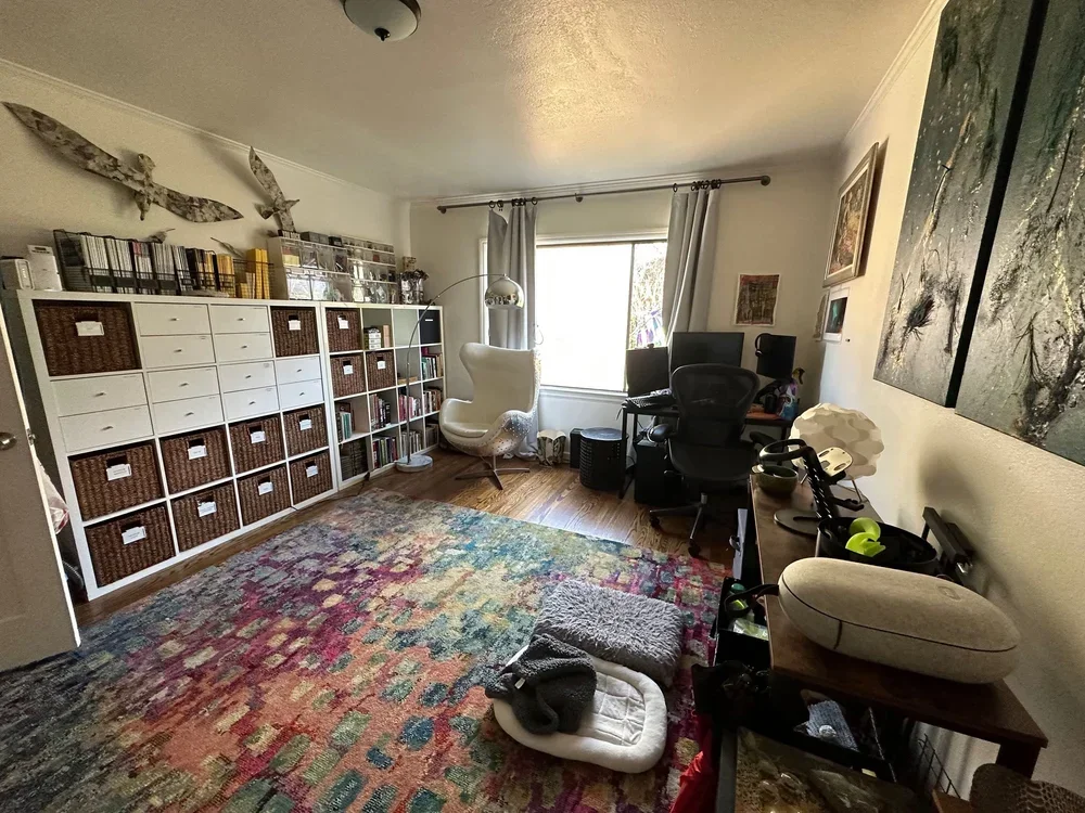 Organized San Francisco home office by Sorted Spaces, featuring white cubby storage with baskets and a colorful rug.