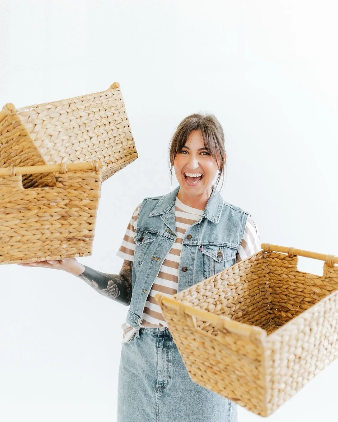 Founder Terrin Marino of Saucha Living smiling while holding woven storage baskets for a home organization project in Fayetteville, NC.