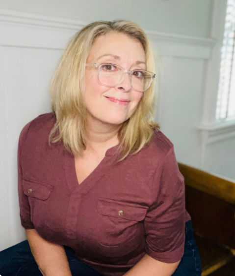 Professional organizer Suzzanne Cafiero of Sweet Spaces smiling in a maroon top and glasses.