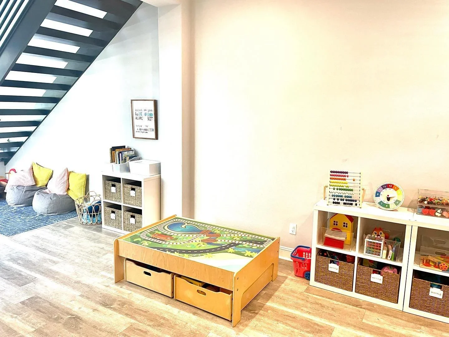 Professional playroom organization by North County Concierge in San Diego, featuring a train table and labeled wicker storage bins.