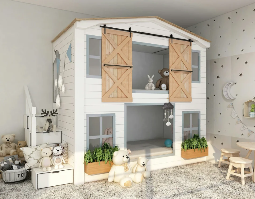 A white barn-style house bunk bed with sliding wood doors, windows with flower boxes, and organized stuffed animals in a bright children's playroom.