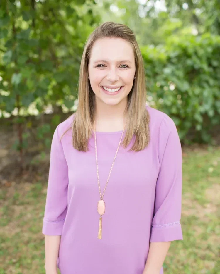 Kelly Patterson, professional organizer, smiling in a purple top outdoors.