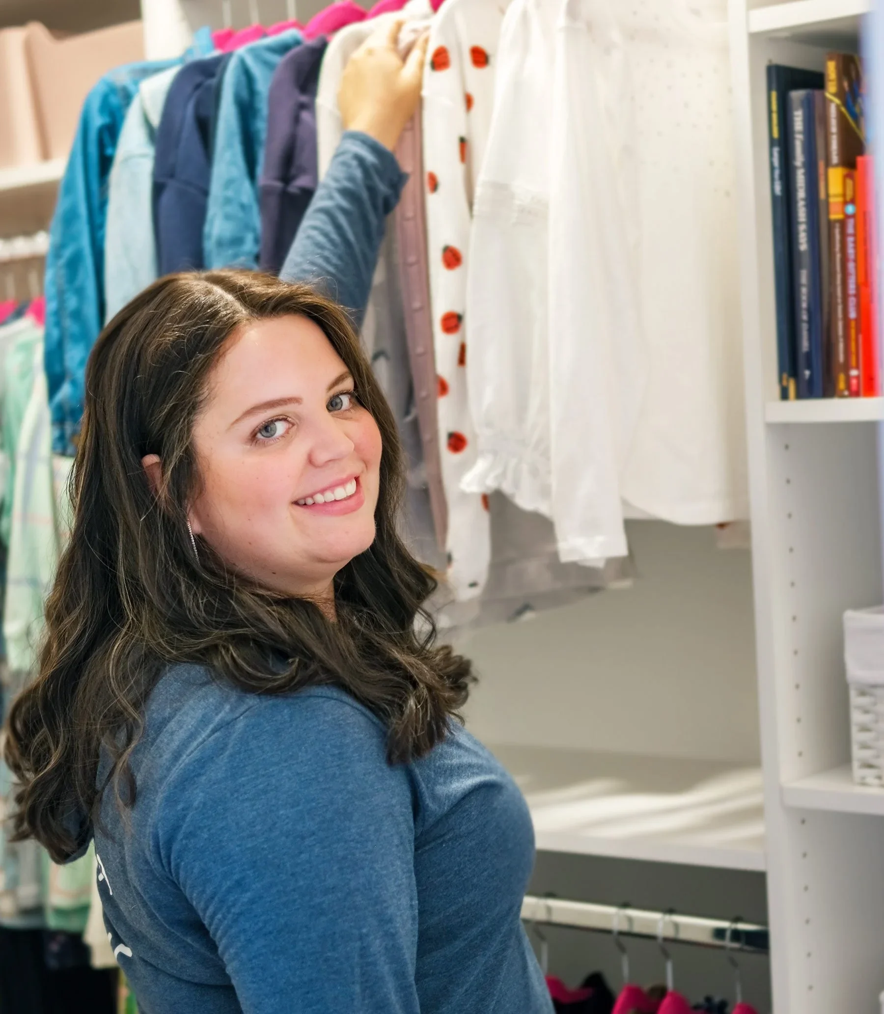 Bracha Hurwitz, professional organizer, smiling while organizing a closet.
