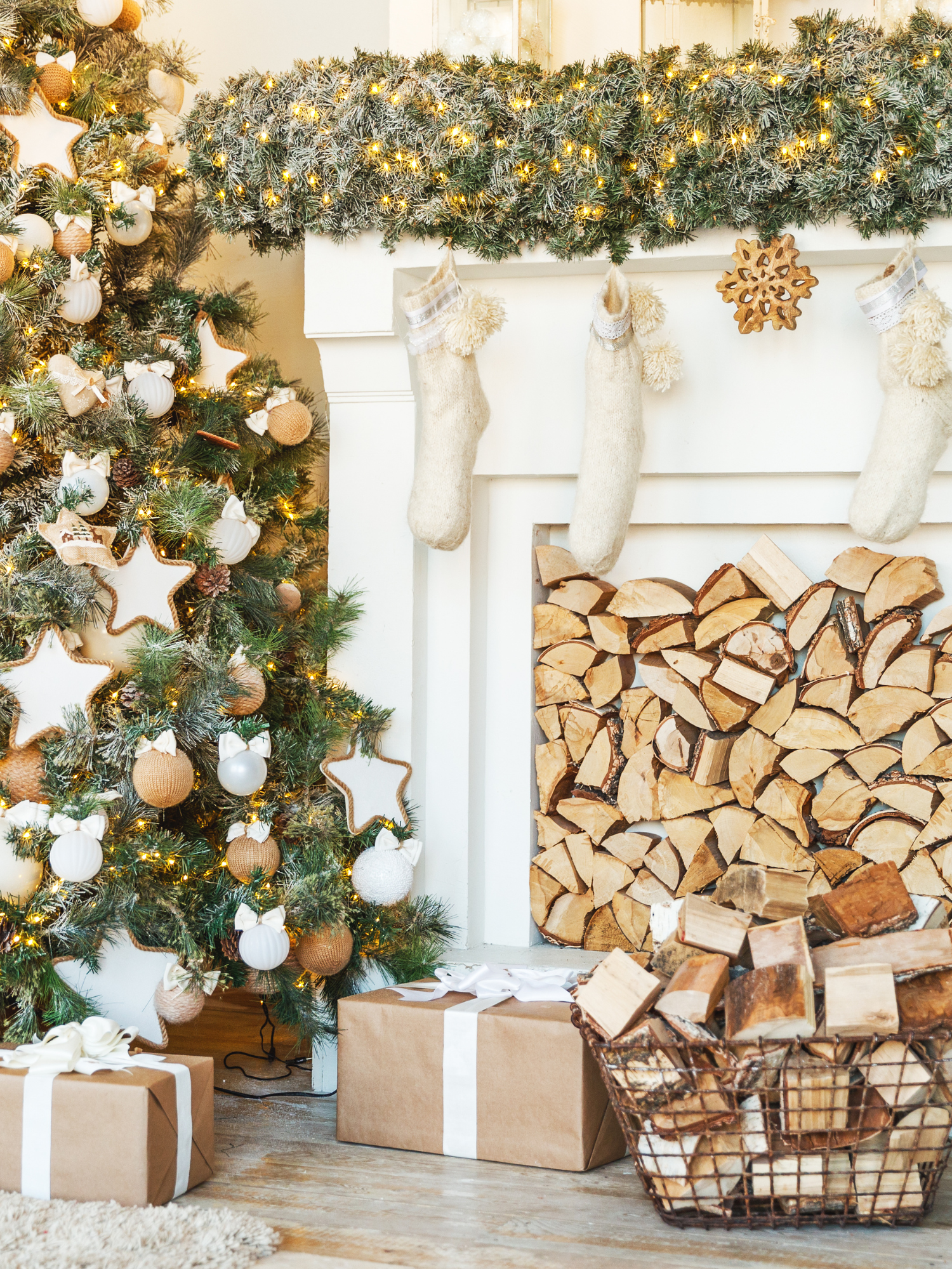 A festive living room styled by Happy Tree Organizing, featuring a decorated Christmas tree, stockings on a white fireplace, and organized firewood.