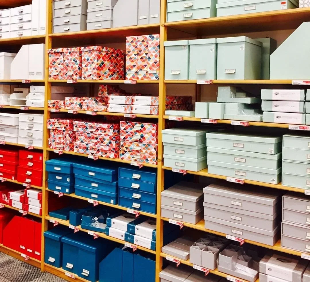 Vibrant, color-coordinated storage boxes and bins neatly organized on wooden shelves by Divine Organization in San Antonio.