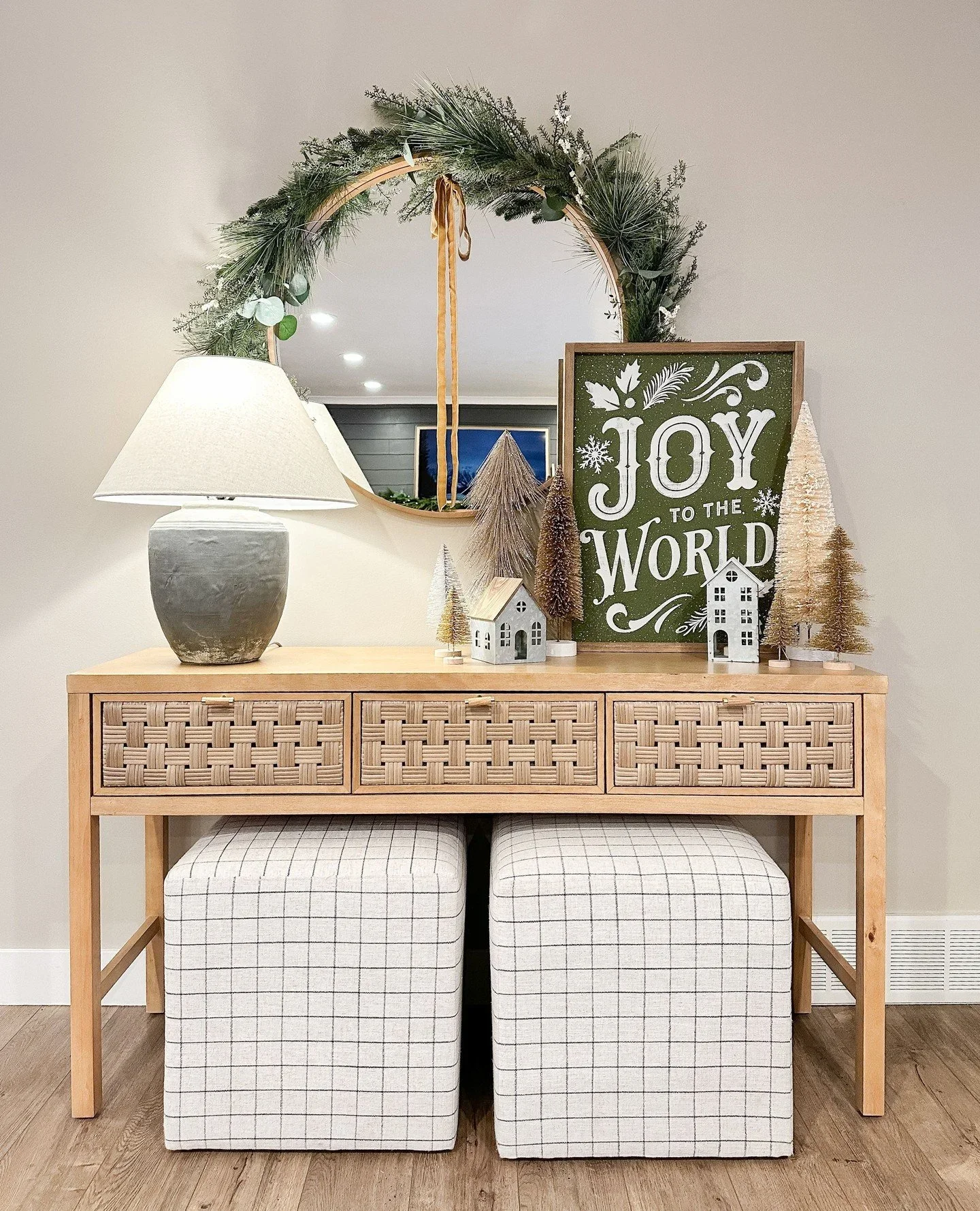 Organized entryway console table with woven drawers, Christmas greenery, and festive decor.