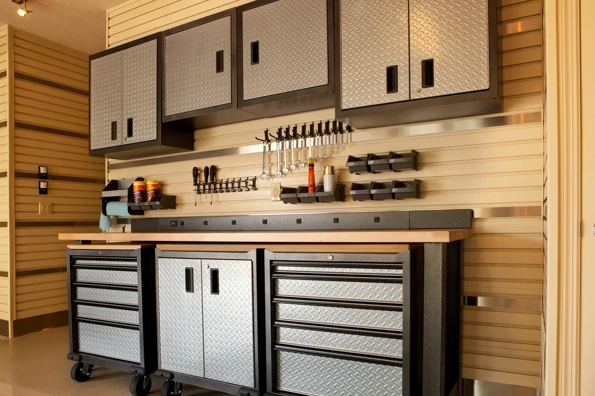 Professional garage organization in Savannah by Simple Hive Organizing, featuring silver diamond-plate cabinets and a slatwall tool storage system.