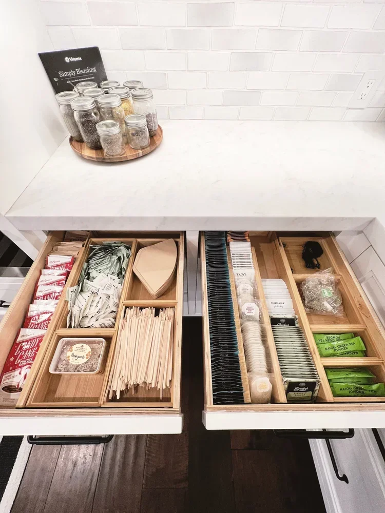Organized tea and coffee drawer with bamboo dividers in a modern kitchen.