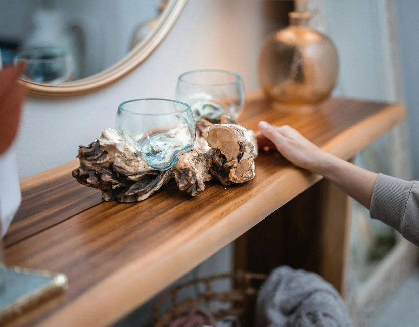 Professional home styling by Julie Aderhold in Green Bay, featuring molten glass bowls on a teak root base atop a wood console table.