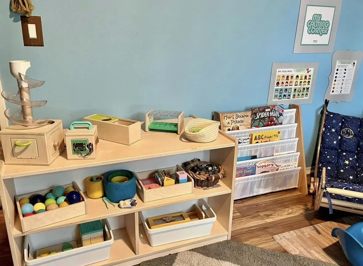Organized children's playroom featuring wooden shelves, toys, and a dedicated calming corner.
