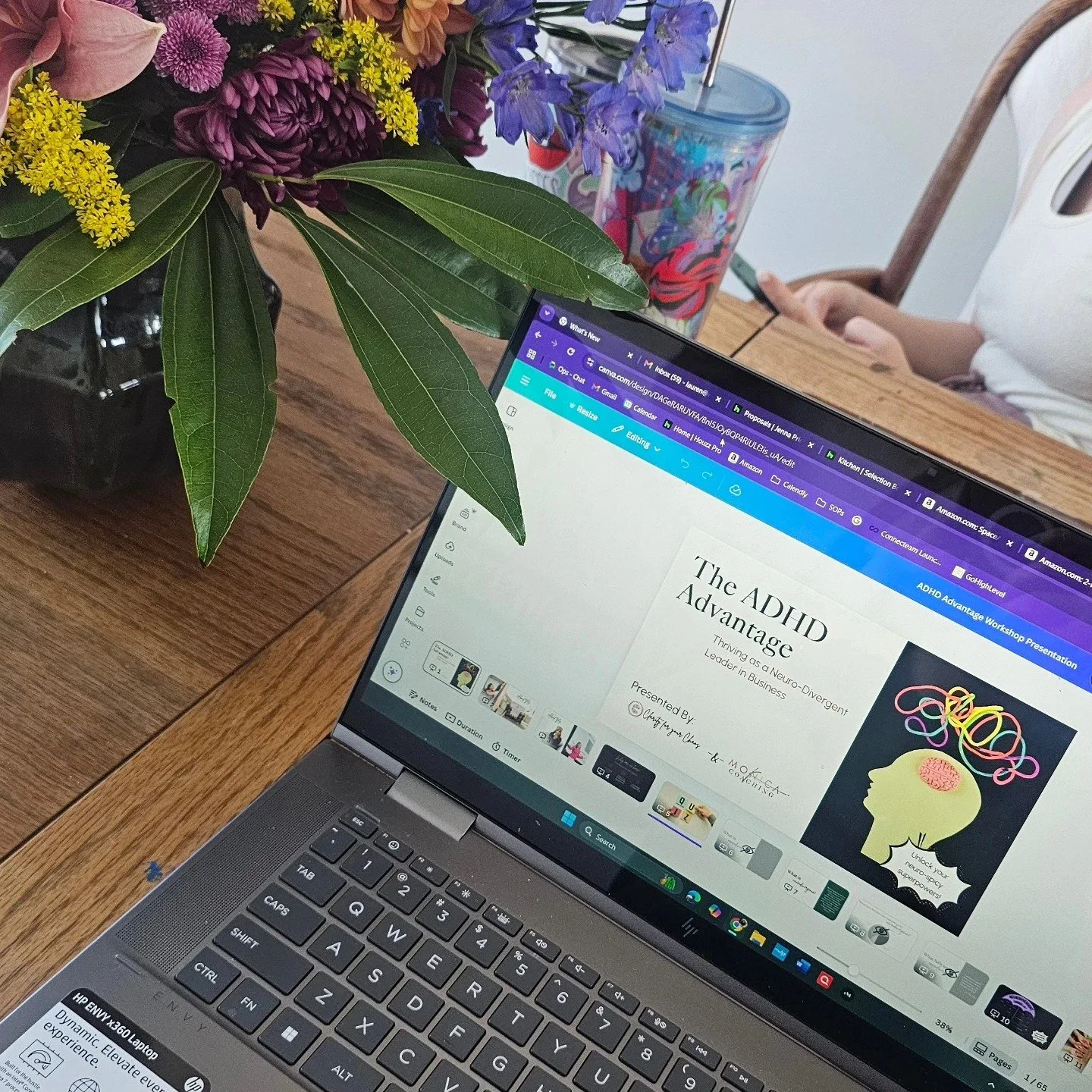 Laptop showing an ADHD Advantage presentation next to a bouquet of flowers in a home office.