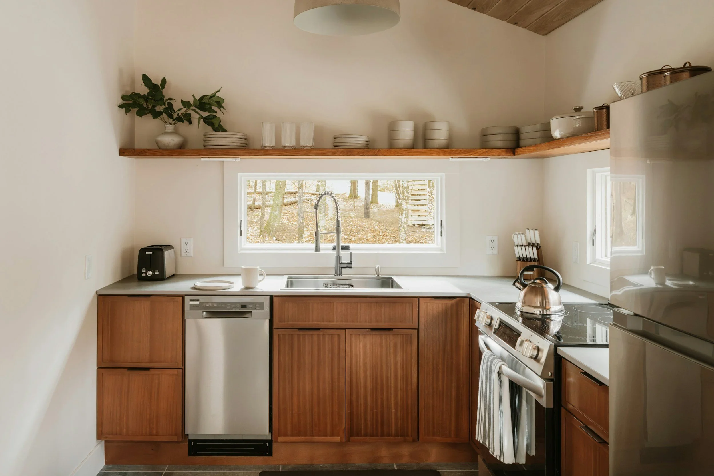 Modern organized kitchen in Houston with natural wood cabinets, open shelving, and neutral tones.